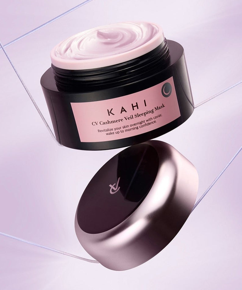 Décris l'image en français : KAHI CV Chashmere Veil Sleeping Mask 50ml, pot sur sol carrelé, crème rose.