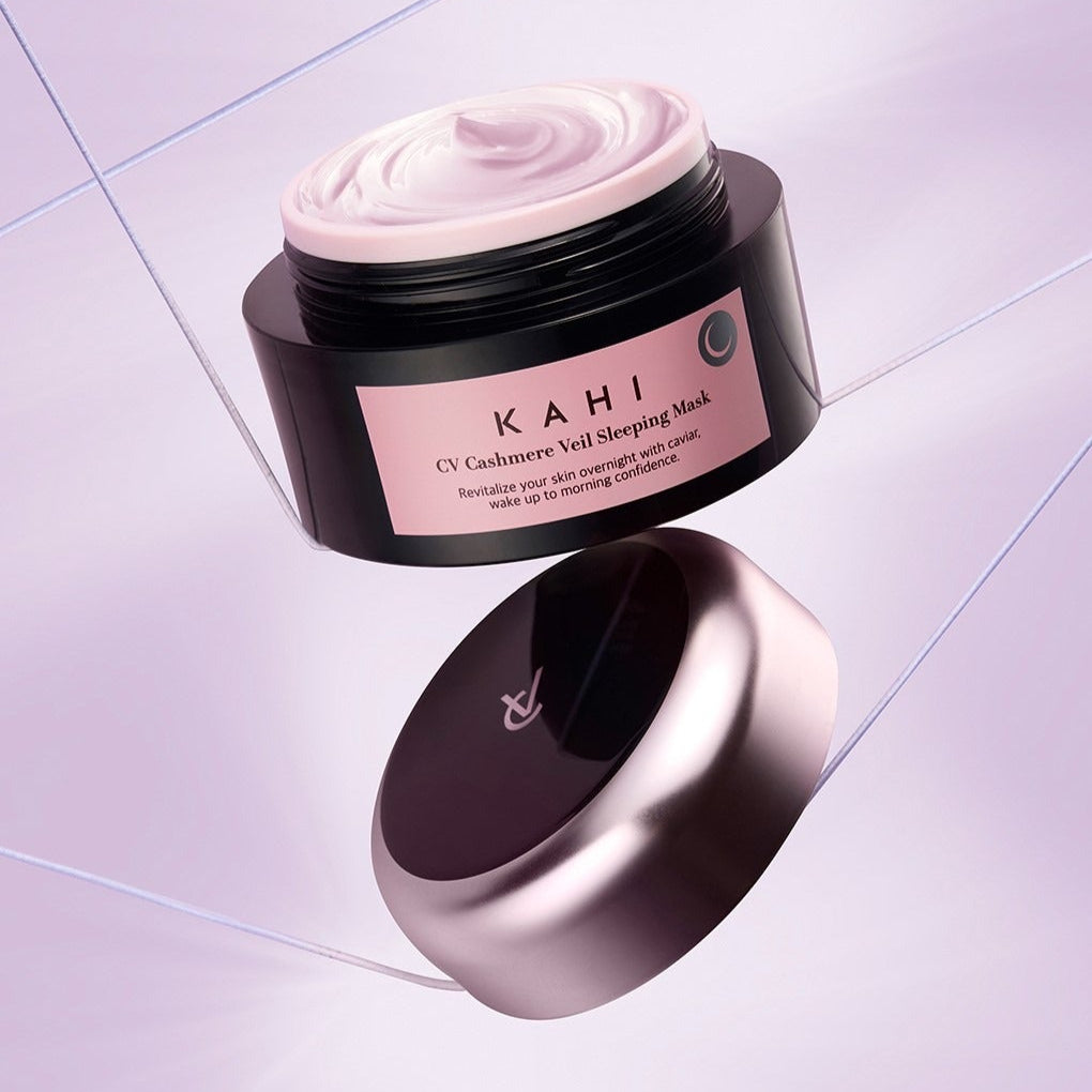 Décris l'image en français : KAHI CV Chashmere Veil Sleeping Mask 50ml, pot sur sol carrelé, crème rose.