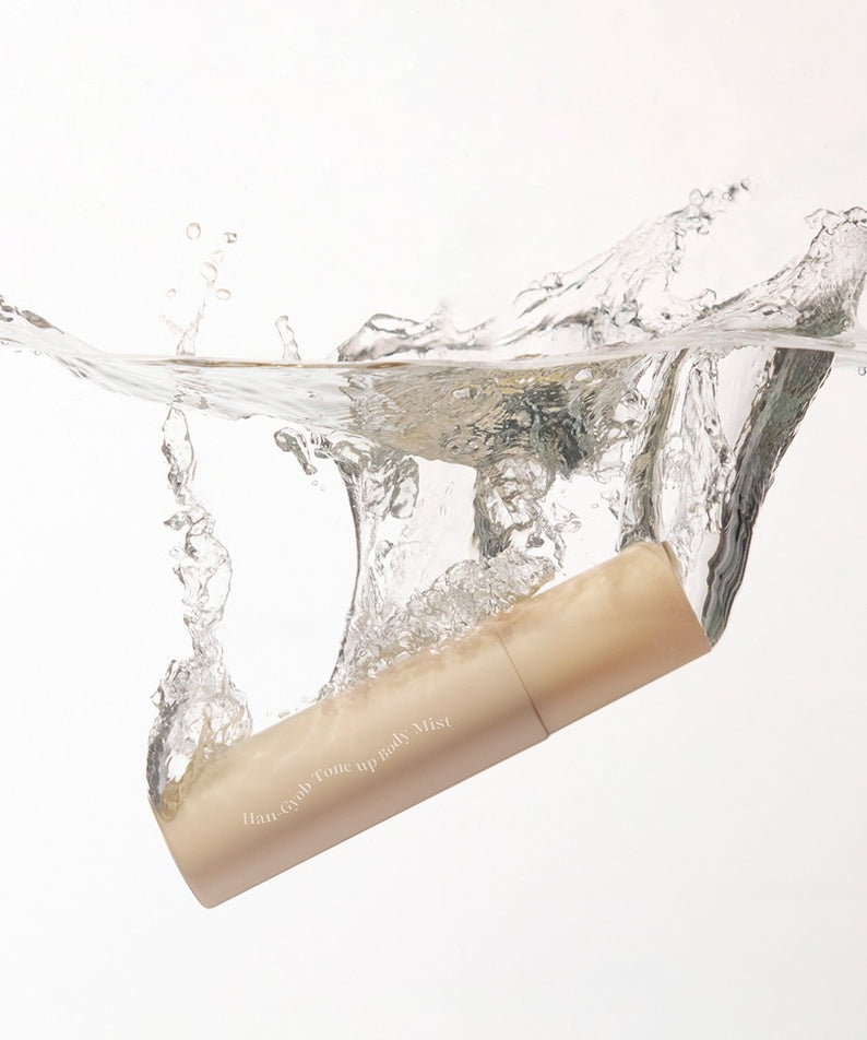 KAHI One Layer Tone-up Body Miist 100ml flottant dans l'eau, produit de beauté hydratant et tonifiant pour le corps, emballage beige élégant.