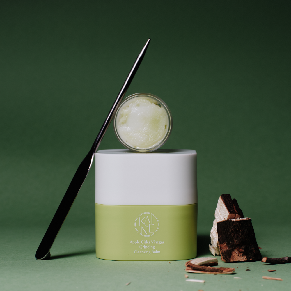 KAINE Apple Cider Vinegar Grinding Cleansing Balm 50ml, baume vert KAINE sur fond vert avec spatule et morceaux
