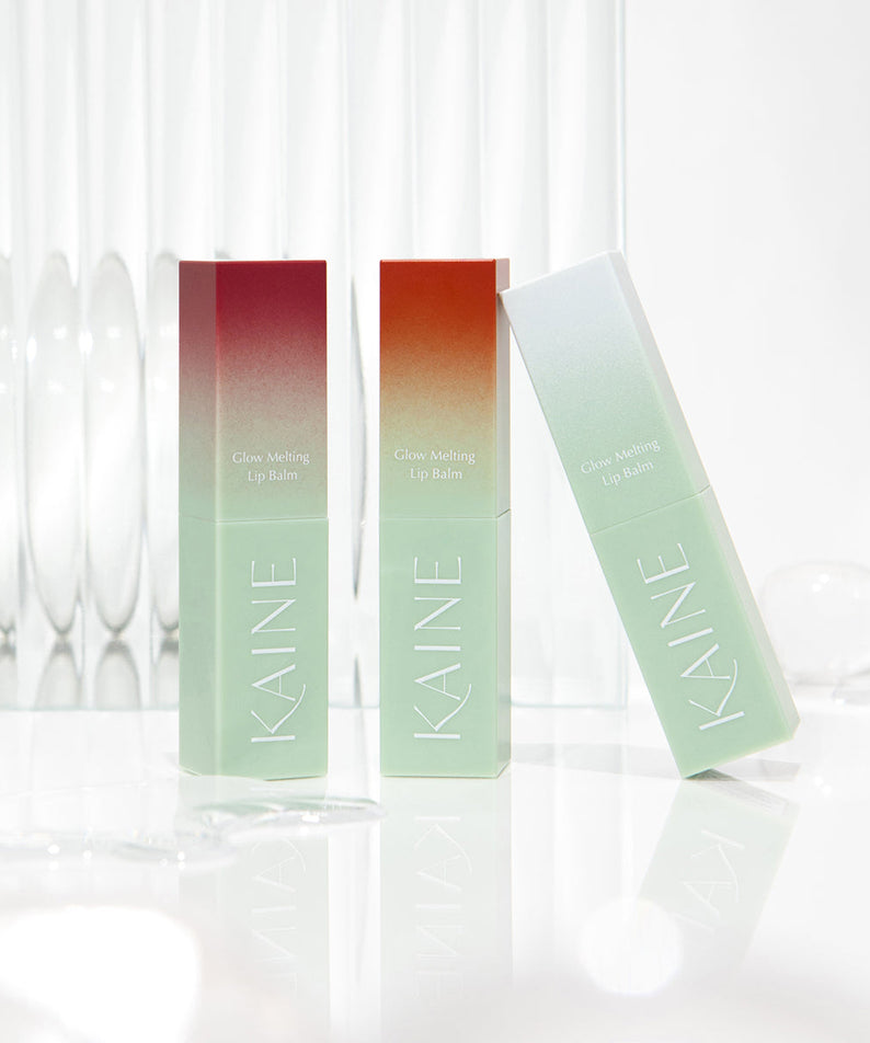 KAINE Glow Melting Lip Balm en présentation élégante avec deux tubes et un fond lumineux, mettant en valeur le design raffiné du produit.