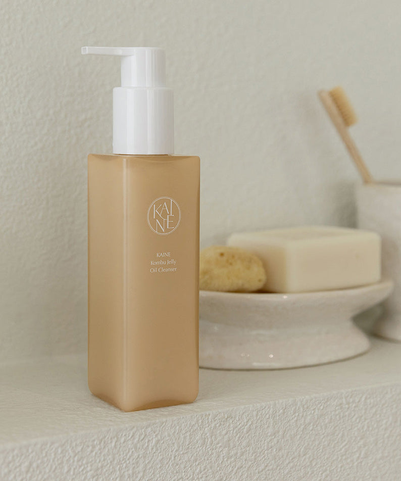 Nettoyant Hydratant KAINE Kombu Jelly Oil Cleanser 145ml avec pompe, sur fond beige élégant. Soin visage nourrissant et naturel.