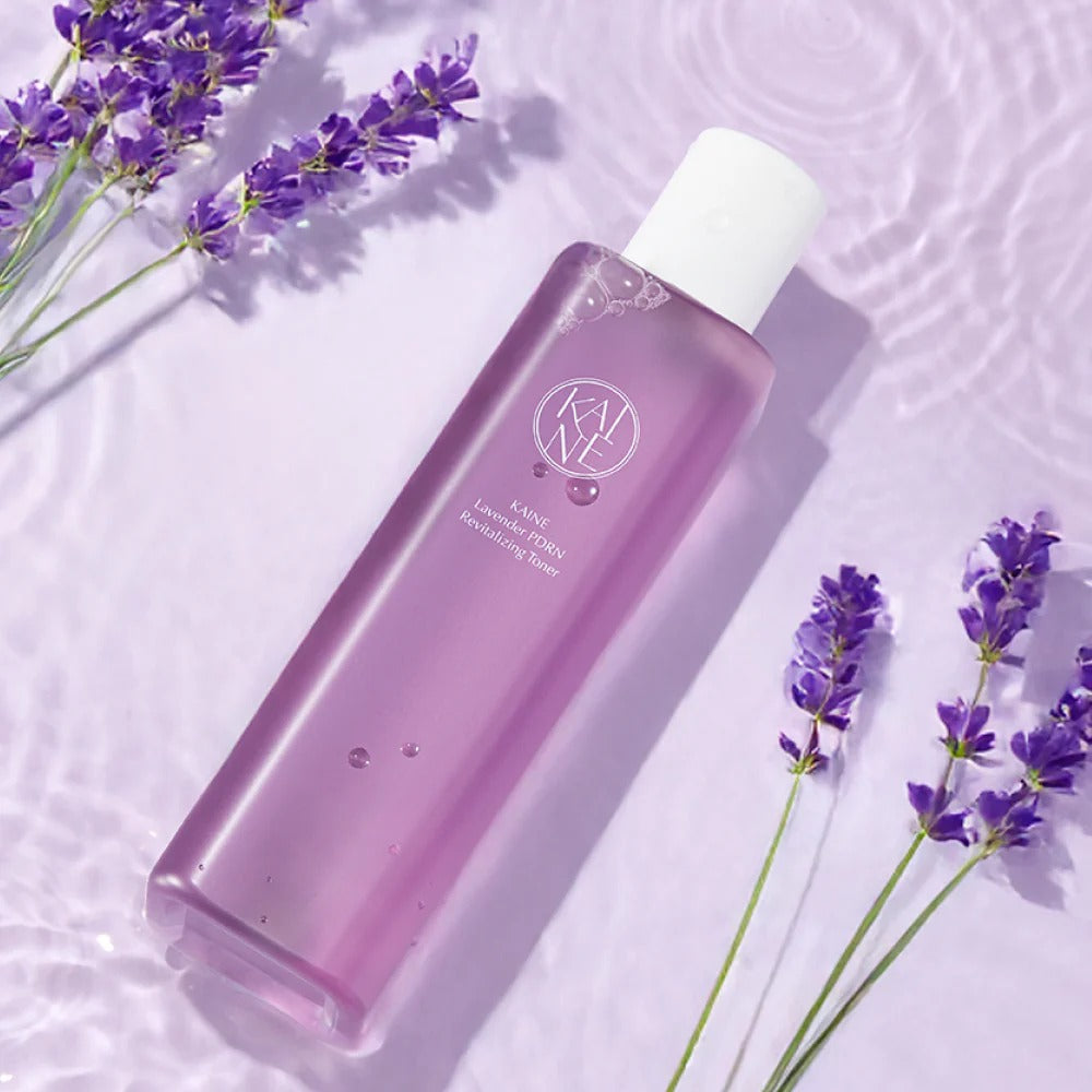 KAINE Lavender PDRN Revitalizing Toner 300ml de KAINE, flacon violet sur fond blanc avec fleurs de lavande.
