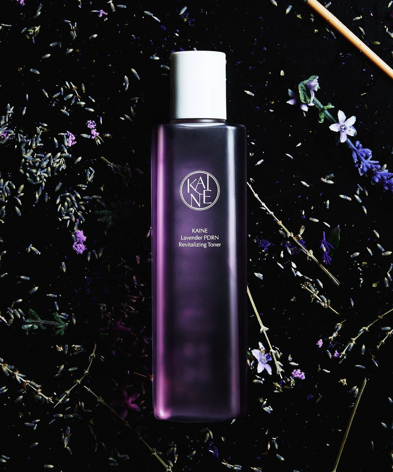 Flacon de KAINE Lavender PDRN Revitalizing Toner 300ml sur fond de fleurs de lavande