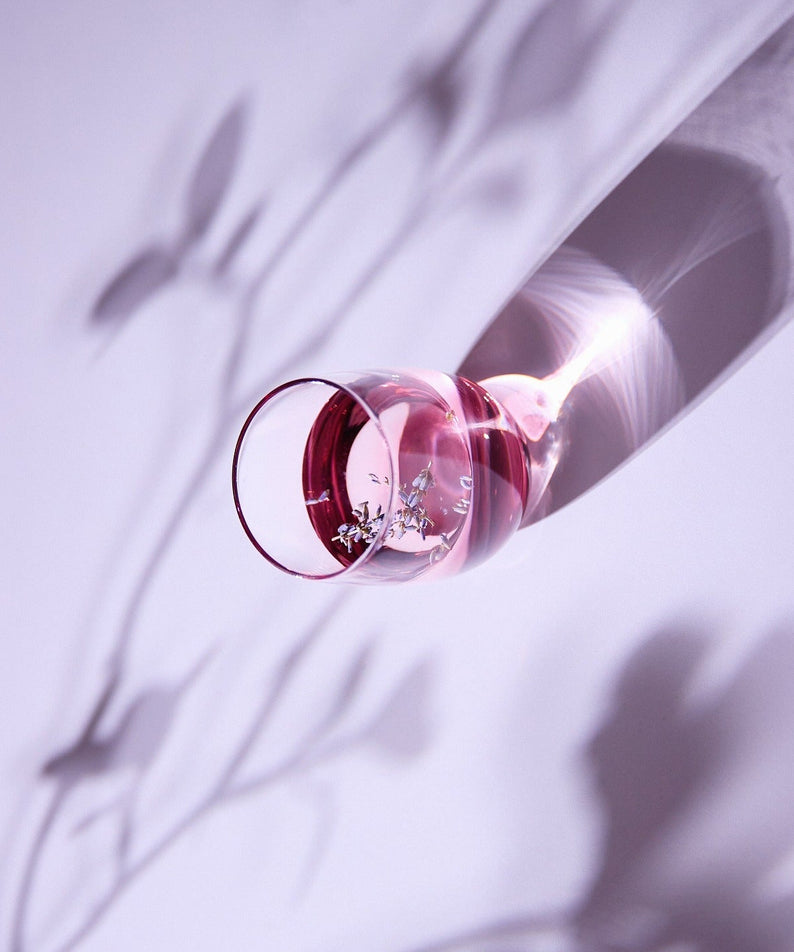 Flacon de KAINE Lavender PDRN Revitalizing Toner 300ml posé sur une surface avec ombres de plantes.