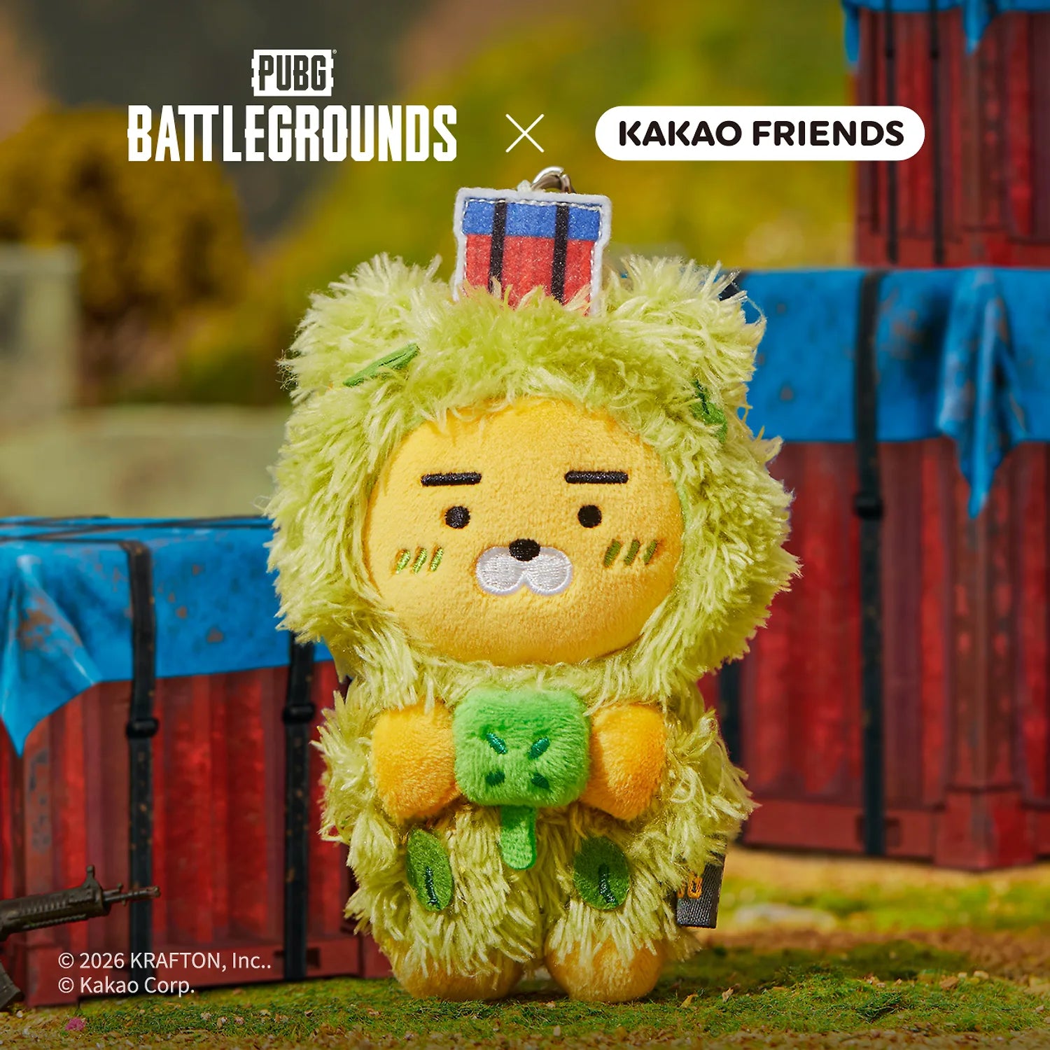 KAKAO FRIENDS Battleground X Friends Keychain Doll, porte-clés peluche jaune face au décor PUBG Battlegrounds