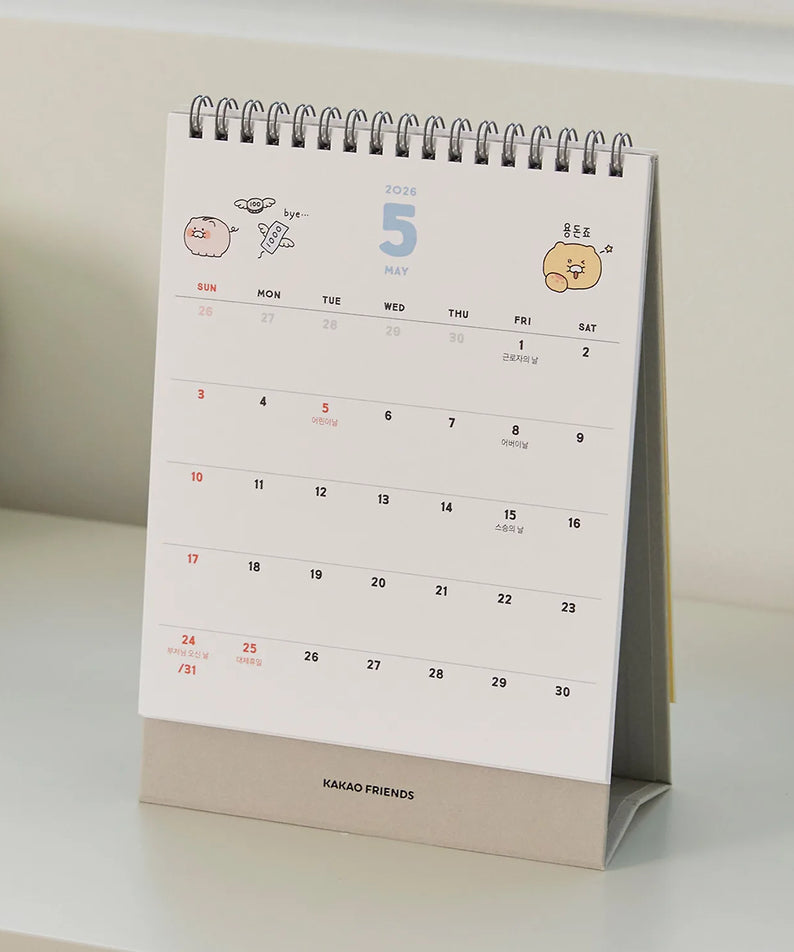 Décris l'image en français : KAKAO FRIENDS Desk Calendar 2026, calendrier de bureau sur un bureau, design mignon.