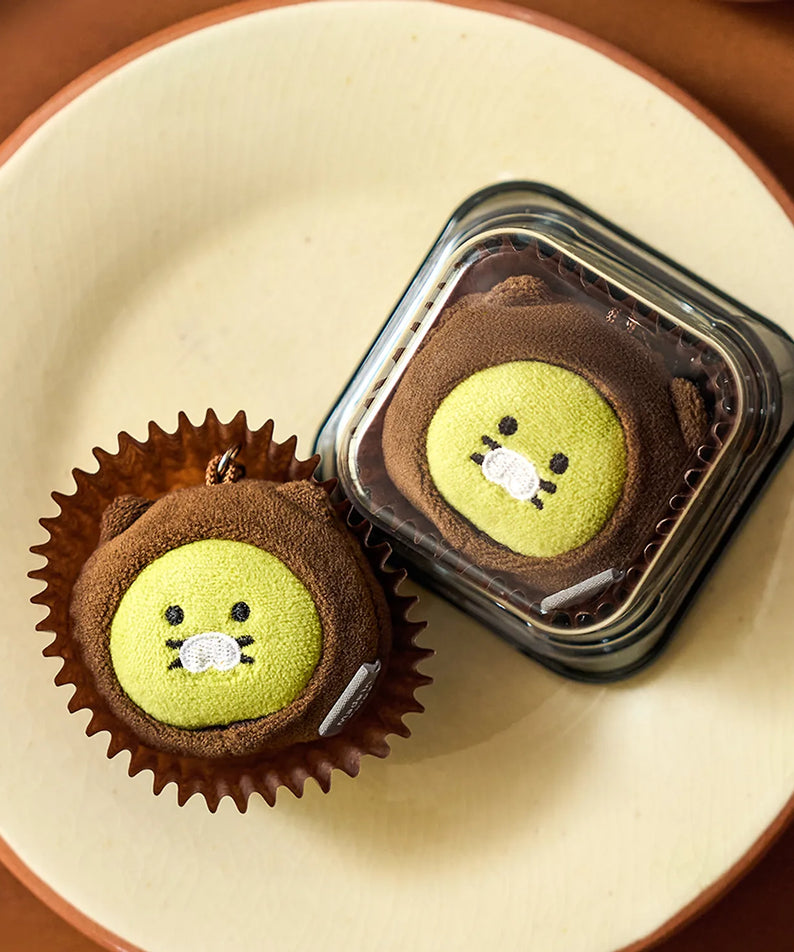 KAKAO FRIENDS Dujjonchun keychain doll : deux personnages en cupcake, présentés sur une assiette, ambiance dessert.