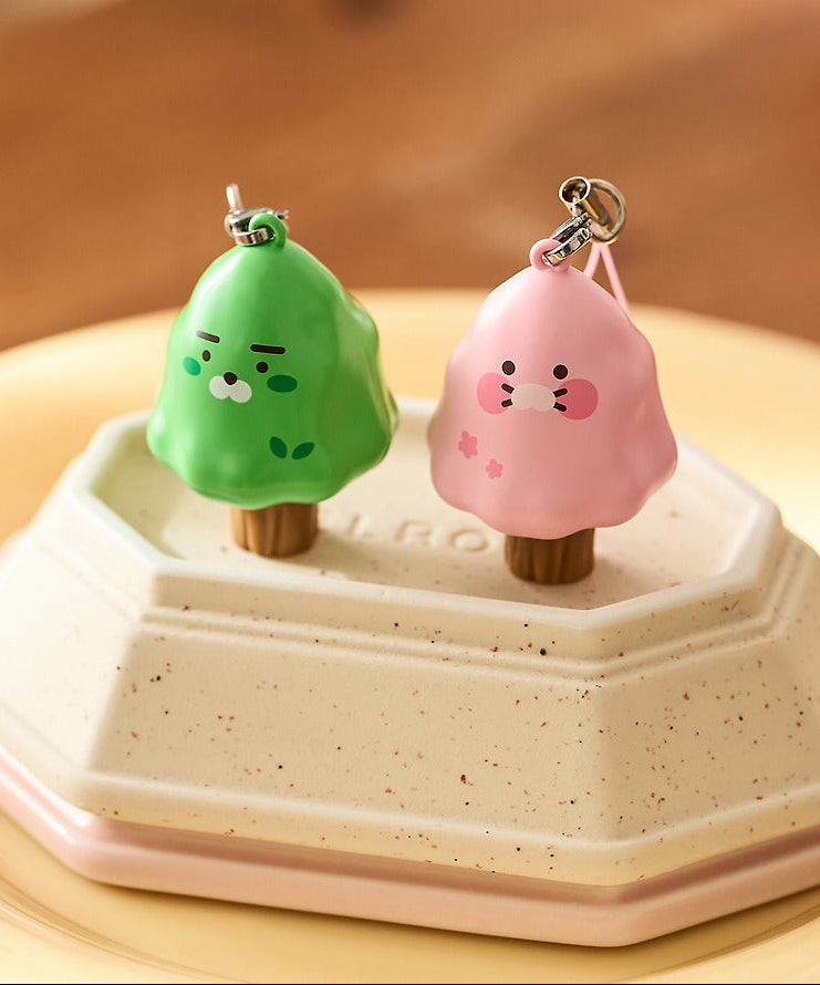 KAKAO FRIENDS Peekaboo Moving Keyring, deux porte-clés mignons animés posés sur une boîte blanche, fond beige.