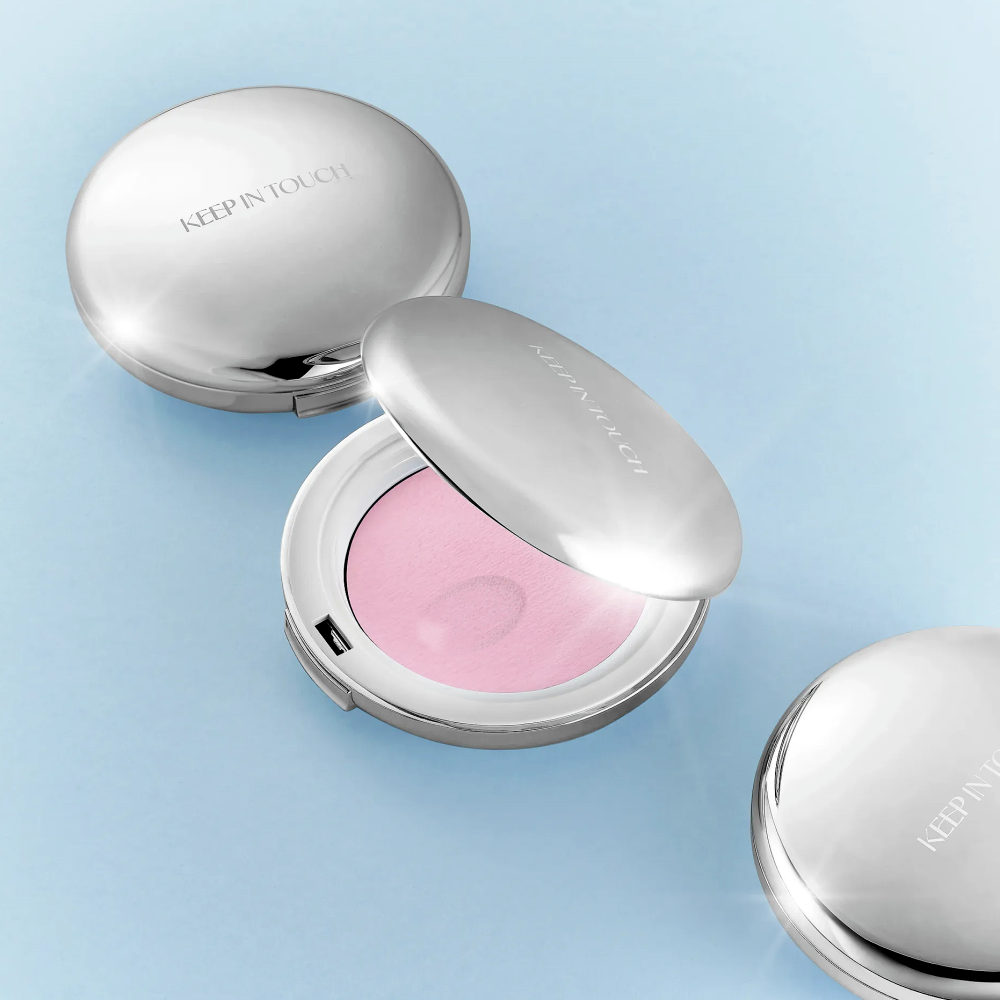 KEEP IN TOUCH Soft Cloud Blur Powder Pact de la marque KEEP IN TOUCH, poudrier et éponge sur fond bleu pastel.