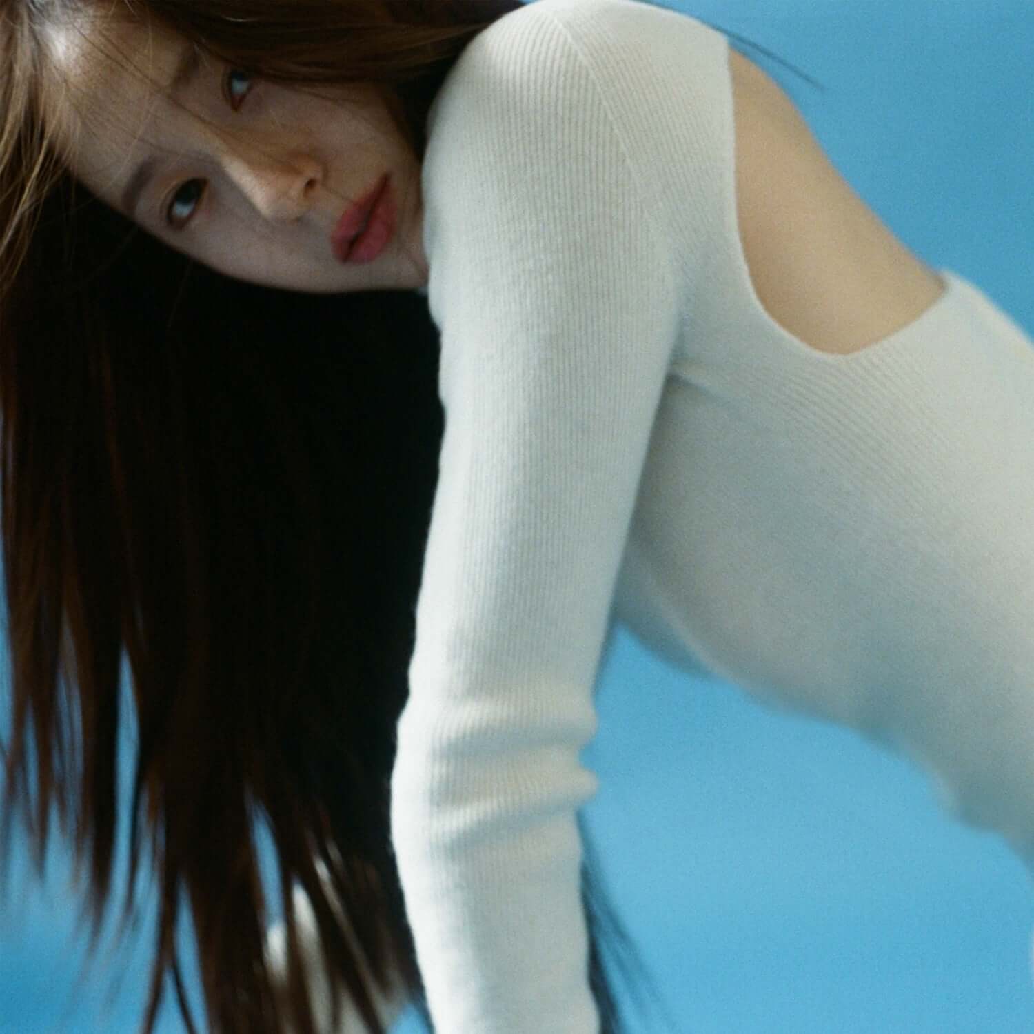 KRYSTAL - [Solitary] - Album Kpop, couverture visuelle : portrait de jeune femme en pull blanc sur fond bleu ciel