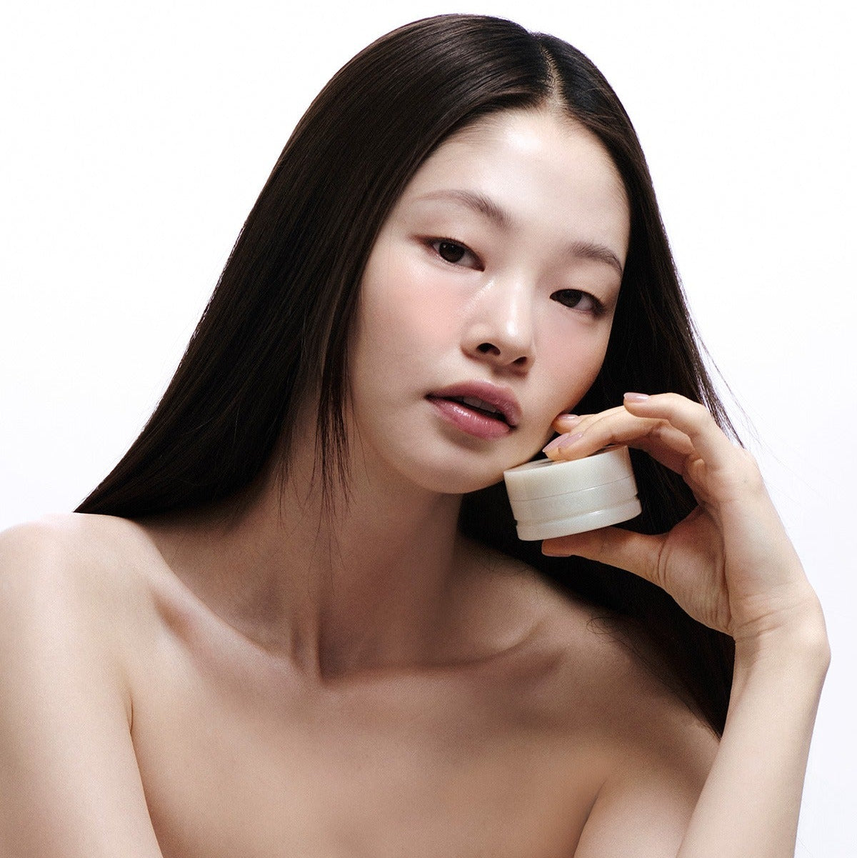 Décris l'image en français : LADOR Body Multi Balm 30g de la marque LADOR, pot de baume appliqué sur la peau, visage femme.