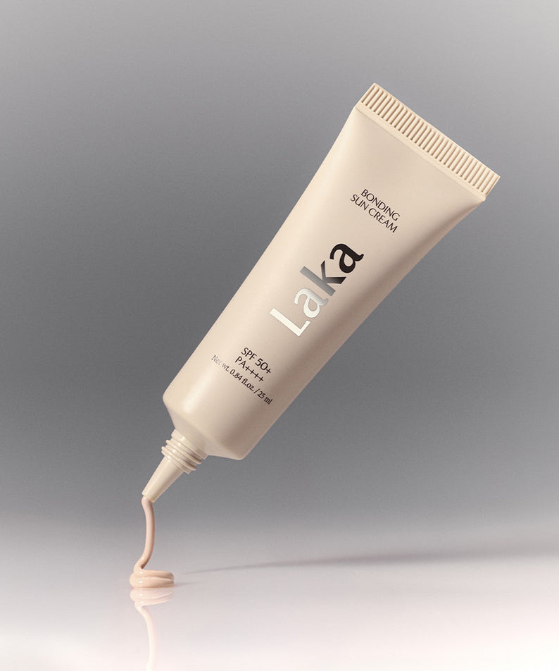 Décris l'image en français : LAKA Bonding Sunscreen 25ml de la marque LAKA, tube crème sur fond gris élégant.