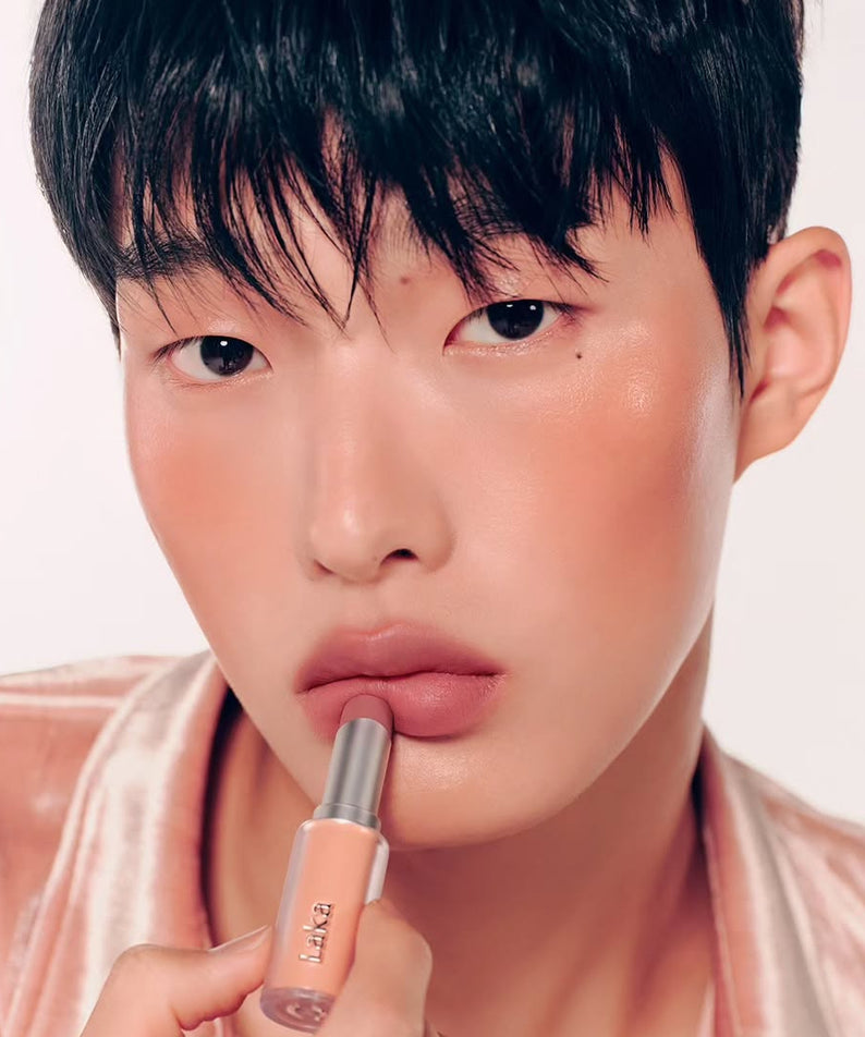 Personne appliquant du LAKA Bulky Matte Lipstick pour un look vibrant et moderne