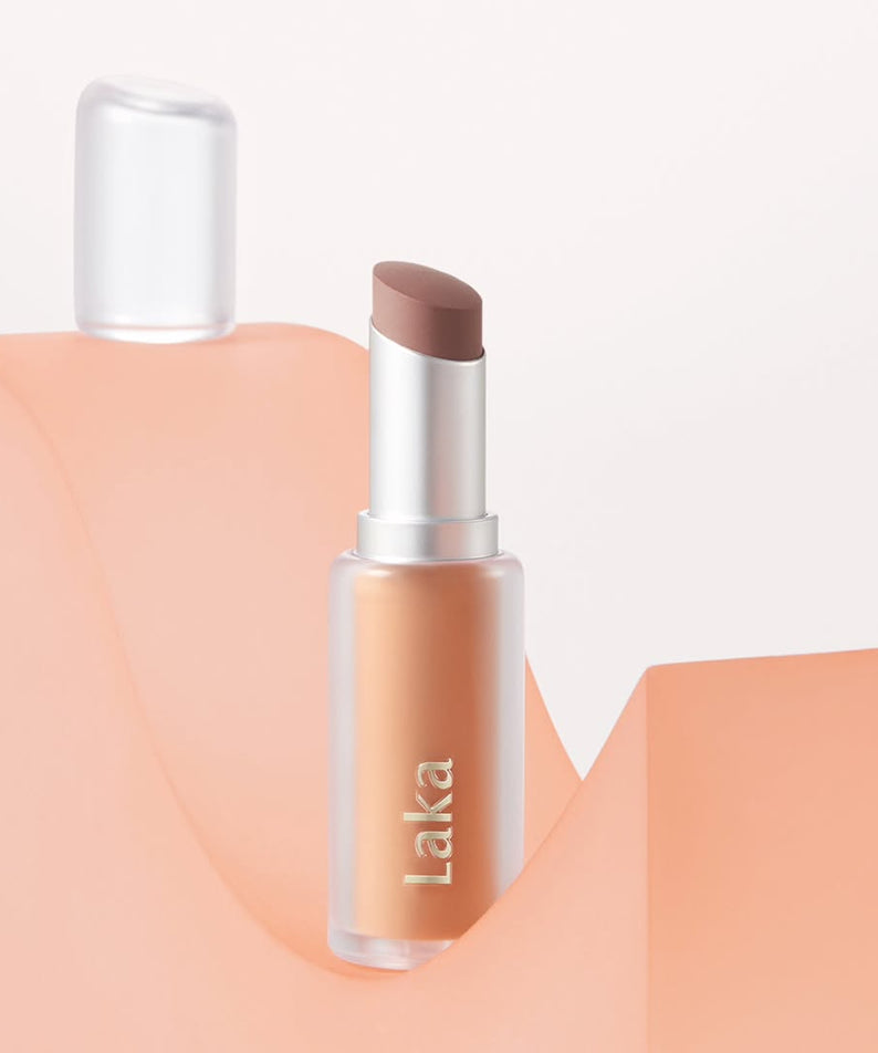 Raffinée et élégante, LAKA Bulky Matte Lipstick sur fond pêche, alliant style moderne et glamour du maquillage.