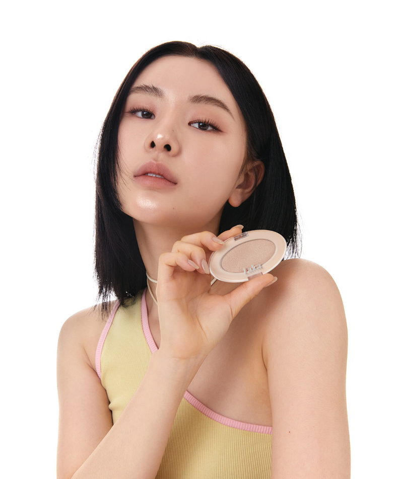 Femme tenant le LAKA DreamBeam Higlighter, produit cosmétique pour un éclat lumineux et naturel.