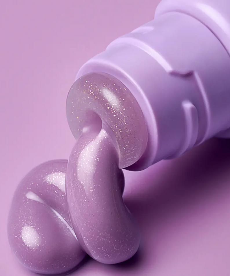 LANEIGE Glaze Craze Tinted Lip Serum, flacon violet et texture scintillante sur fond rose pastel, gros plan.