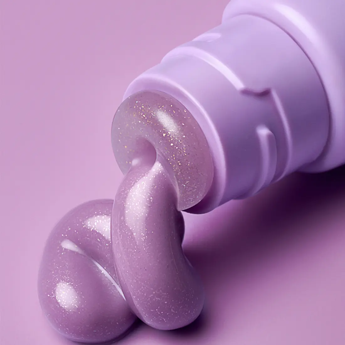 LANEIGE Glaze Craze Tinted Lip Serum, flacon violet et texture scintillante sur fond rose pastel, gros plan.