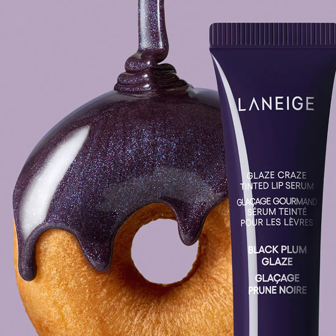 Décris l'image en français : LANEIGE Glaze Craze Tinted Lip Serum, tube et texture violette brillante sur fond clair.
