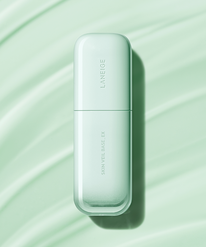LANEIGE Skin Veil Base SPF28/PA++ 30ml, flacon blanc sur fond vert à rayures, mise en scène maquillage.