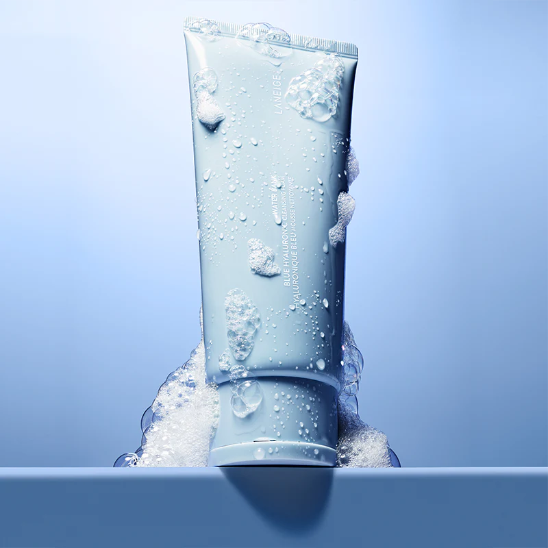 LANEIGE Water Bank Blue Hyaluronic Cleansing Foam 150g, tube bleu sur fond aquatique, gouttes et bulles d’eau.