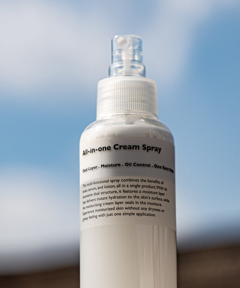 LAZY SOCIETY All-in-One Cream Spray 120ml, bouteille crème spray sur fond bleu ciel, produit beauté de la marque.