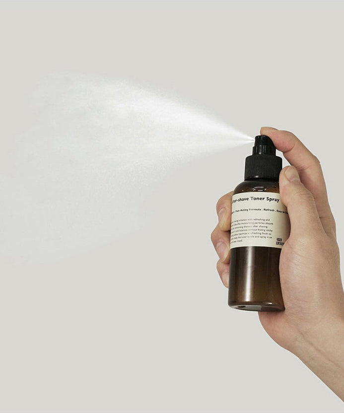 LAZY SOCIETY Cica Aftershave Toner Spray 120ml, main tenant le spray sur fond clair, produit beauté apaisant