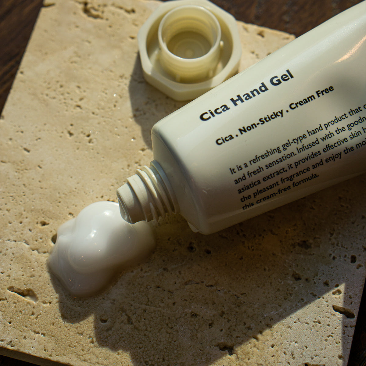 LAZY SOCIETY Cica Hand Gel 50ml, tube de gel hydrogel à la cica sur sable, visuel produit en plein air.
