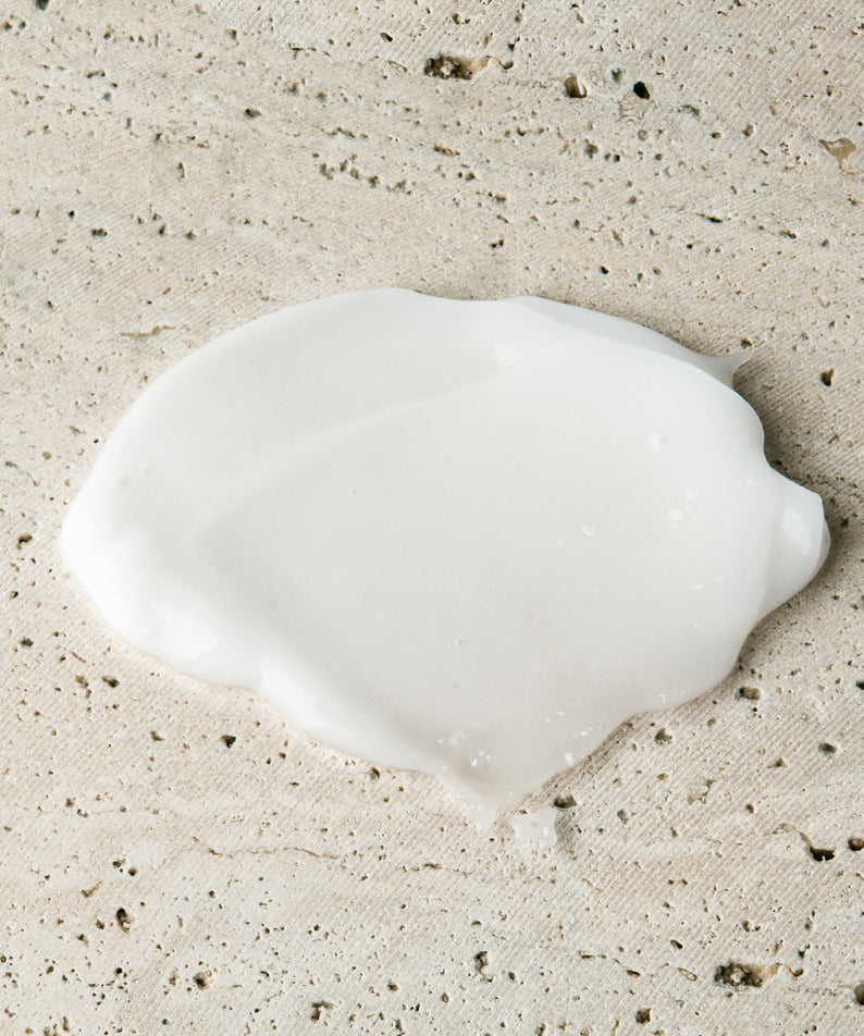 Décris l'image en français : LAZY SOCIETY Cica Hand Gel 50ml, marque sur gel crème sur serviette beige, gouttes visibles.