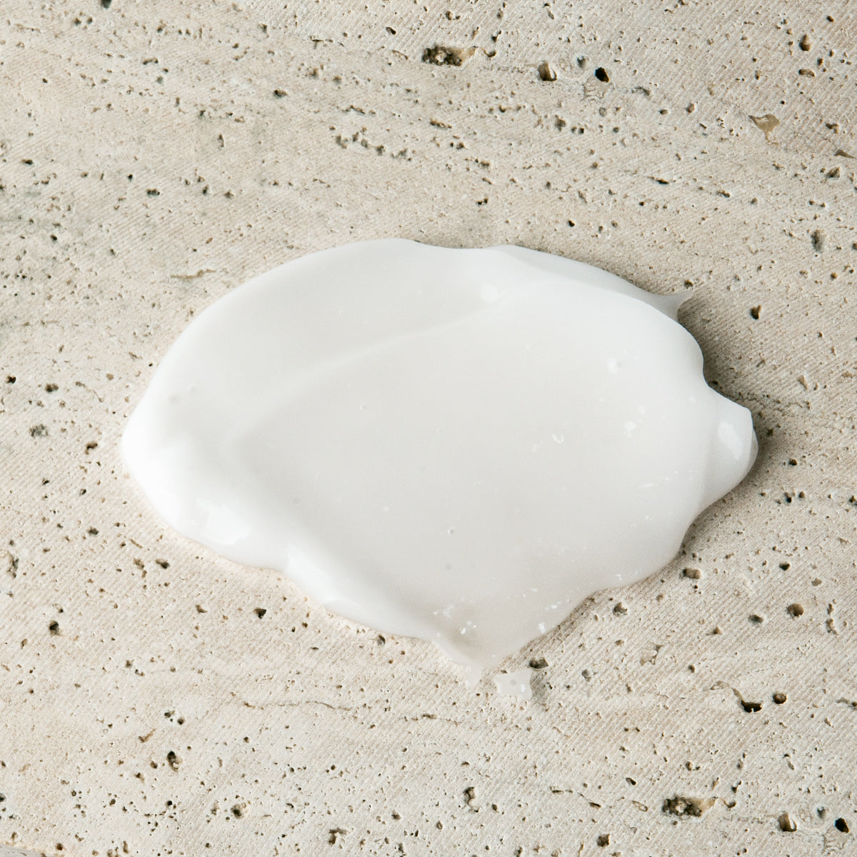 Décris l'image en français : LAZY SOCIETY Cica Hand Gel 50ml, marque sur gel crème sur serviette beige, gouttes visibles.