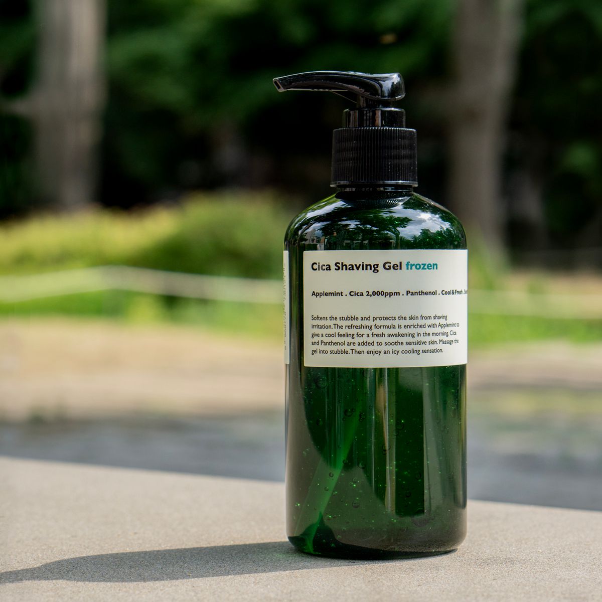 LAZY SOCIETY Cica Shaving Frozen 250ml, gel à raser à la pompe, flacon vert sur route en extérieur.