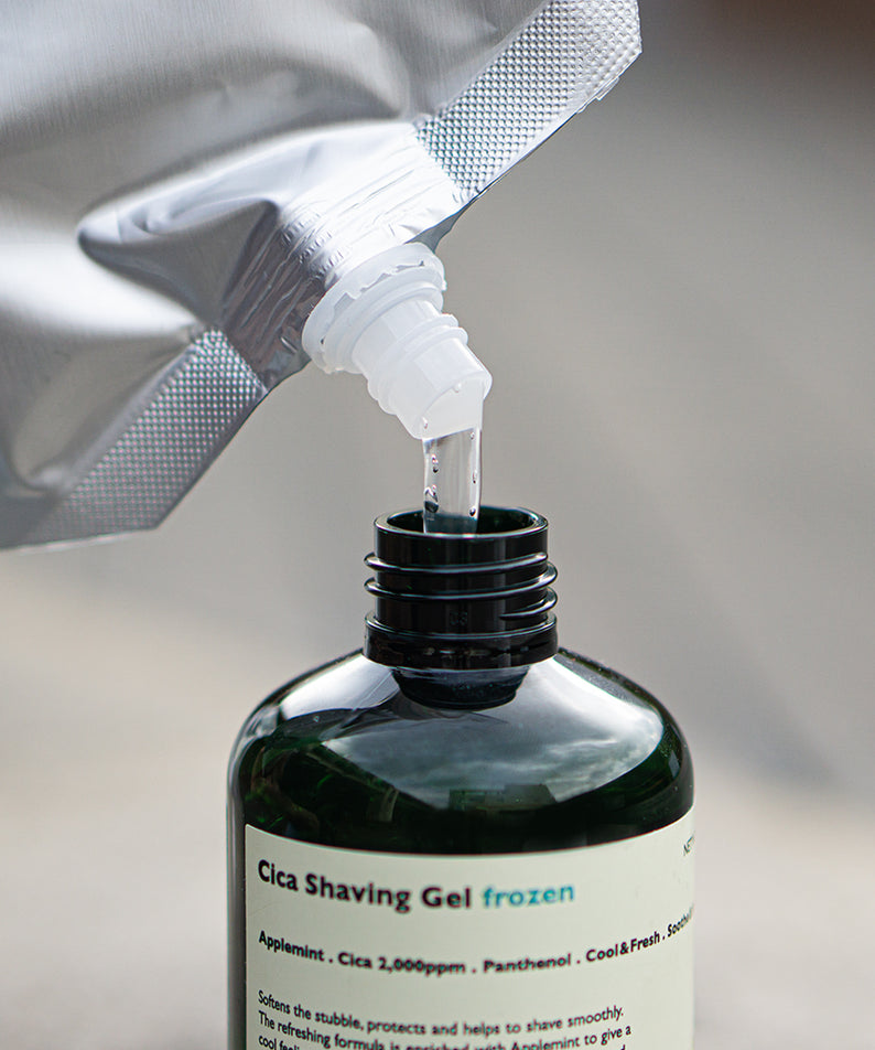 LAZY SOCIETY Frozen Shaving Gel Refill Set : gel à raser versé depuis un sachet, marque visible sur flacon noir.