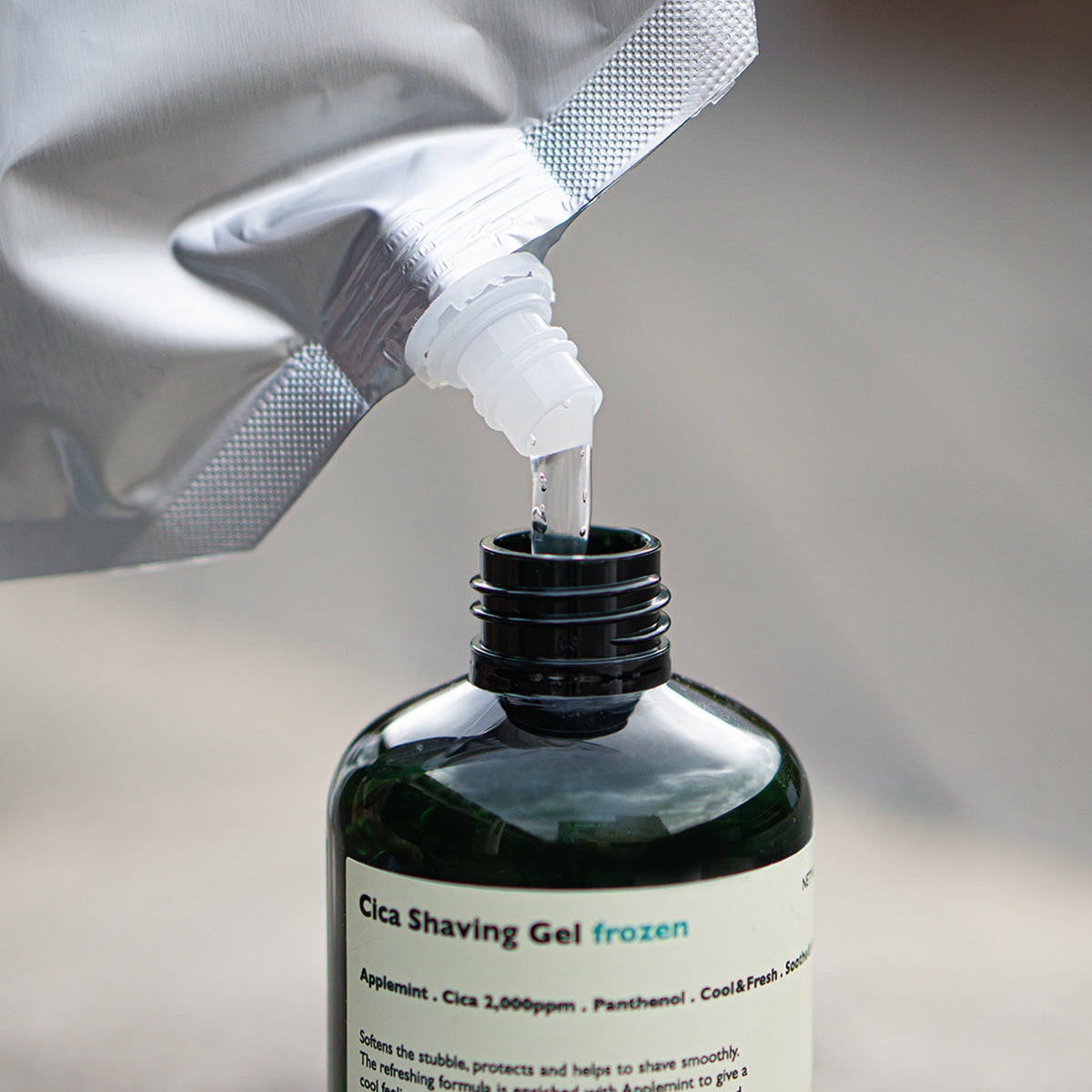 LAZY SOCIETY Frozen Shaving Gel Refill Set : gel à raser versé depuis un sachet, marque visible sur flacon noir.