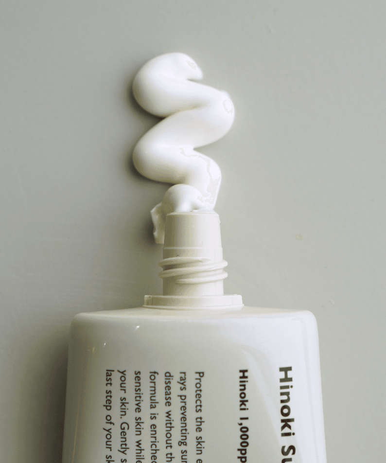 LAZY SOCIETY Hinoki Sunscreen SPPF 50+ PA+++ 50ml, flacon crème solaire sur fond neutre, contexte minimaliste.