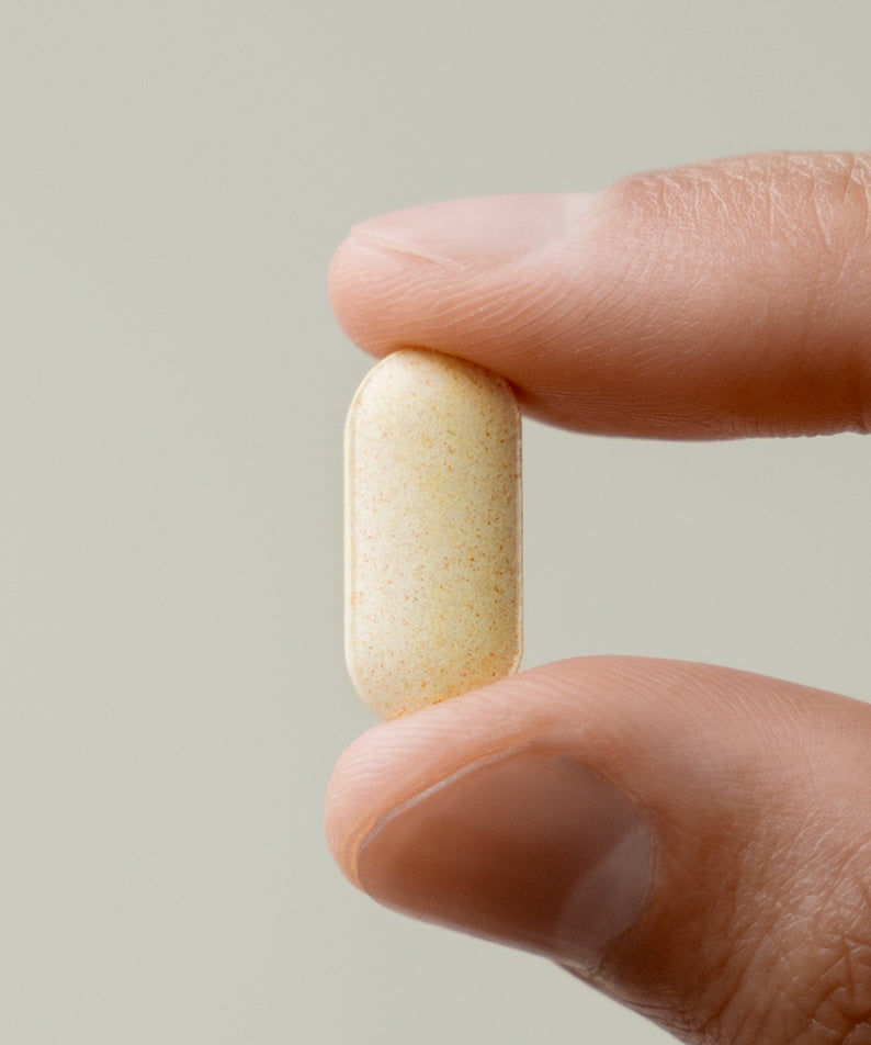 LAZY SOCIETY Multivitamin & Mineral Vitamin B 1000 : gélule tenue par les doigts, fond clair, visuel produit marque Lazy Society.