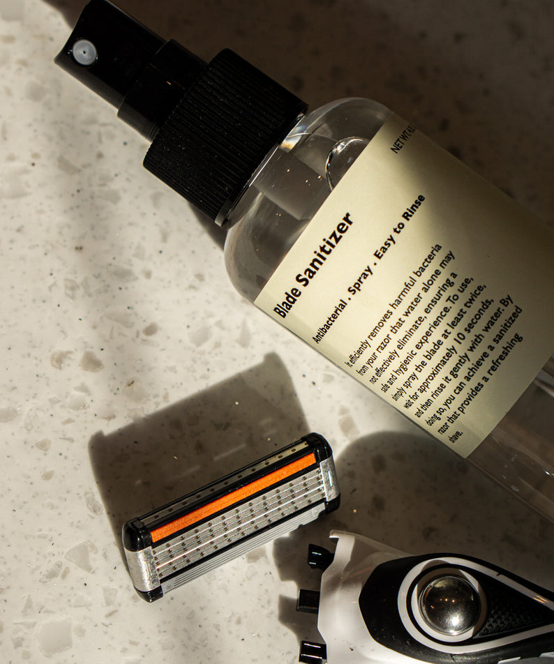 LAZY SOCIETY Razor Blade Sanitizer 120ml : spray sur rasoir, flacon de la marque sur évier en pierre.