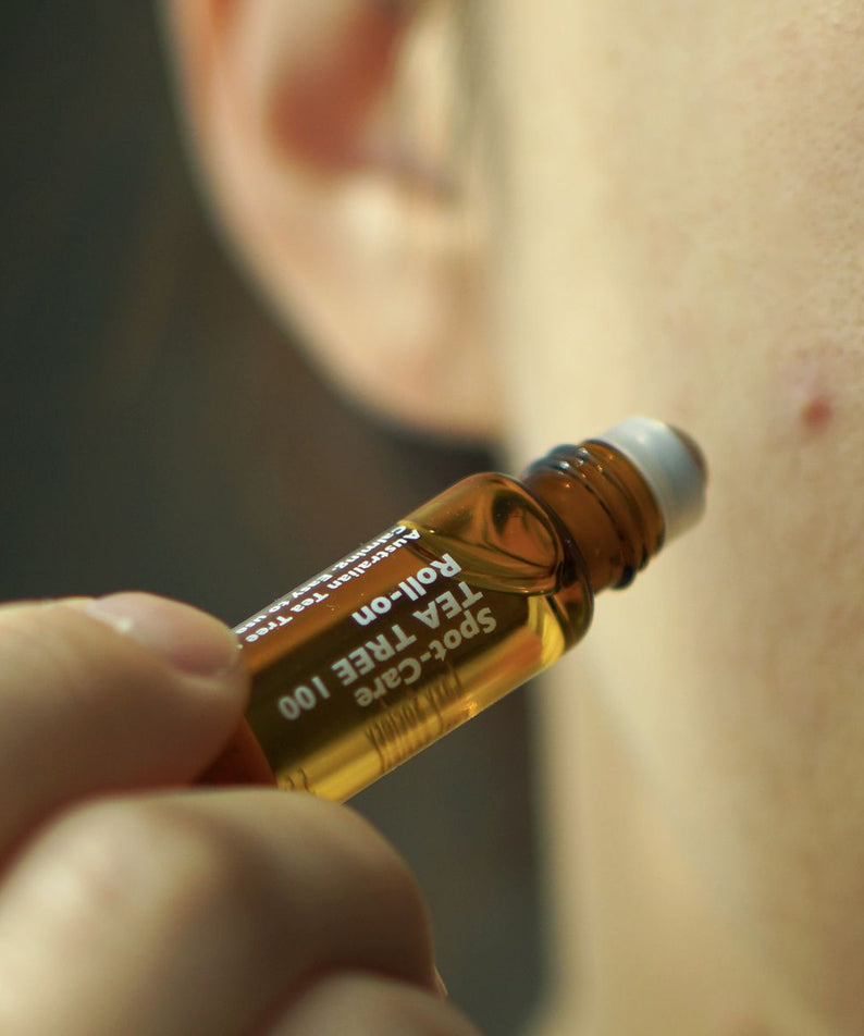 LAZY SOCIETY Spot Care Tea Tree 100 Roll on 5.5ml, huile anti-imperfections au tea tree, appliquée sur peau, gros plan.