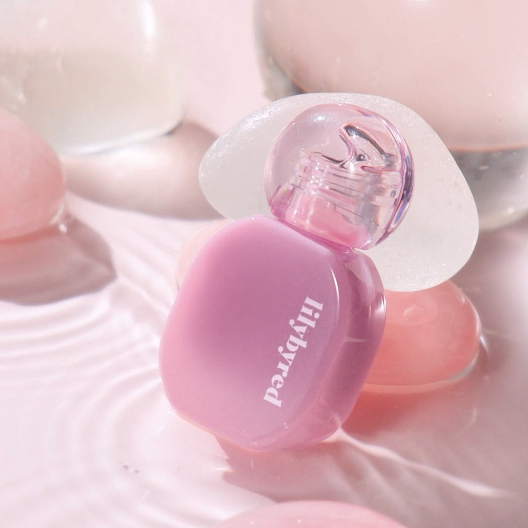 LILYBYRED Balming Dewy Tint de la marque LILYBYRED, flacon violet sur fond rose, gros plan lumineux