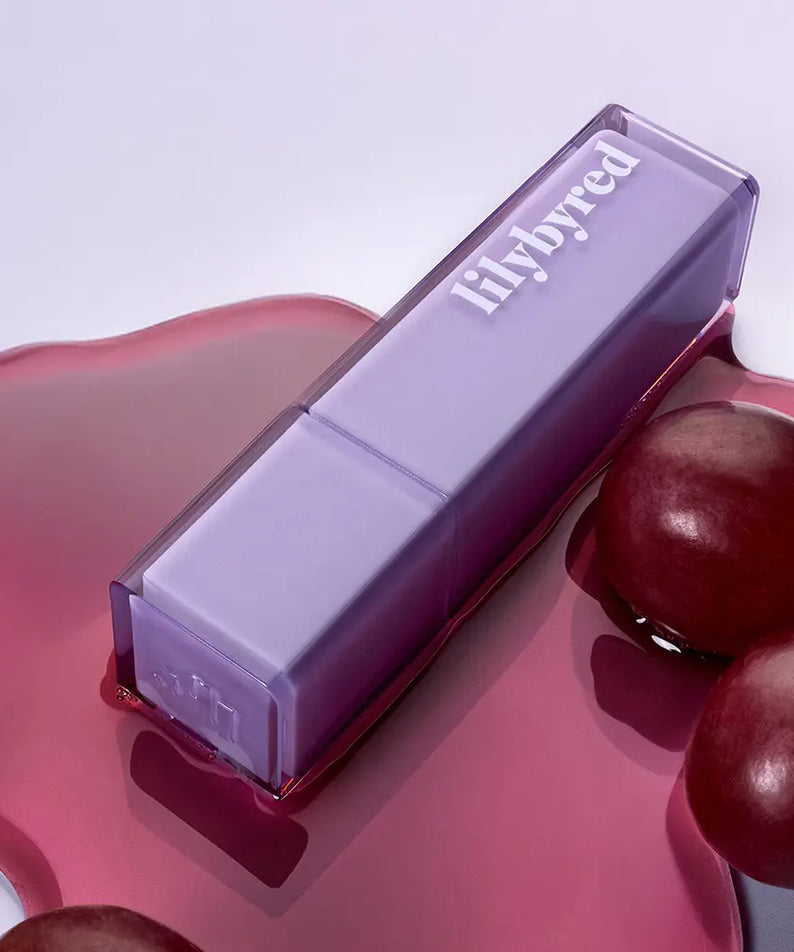 LILYBYRED Bloody Coating Tint de la marque LILYBYRED, tube violet sur fond rose avec gouttes rouges, visuel maquillage.