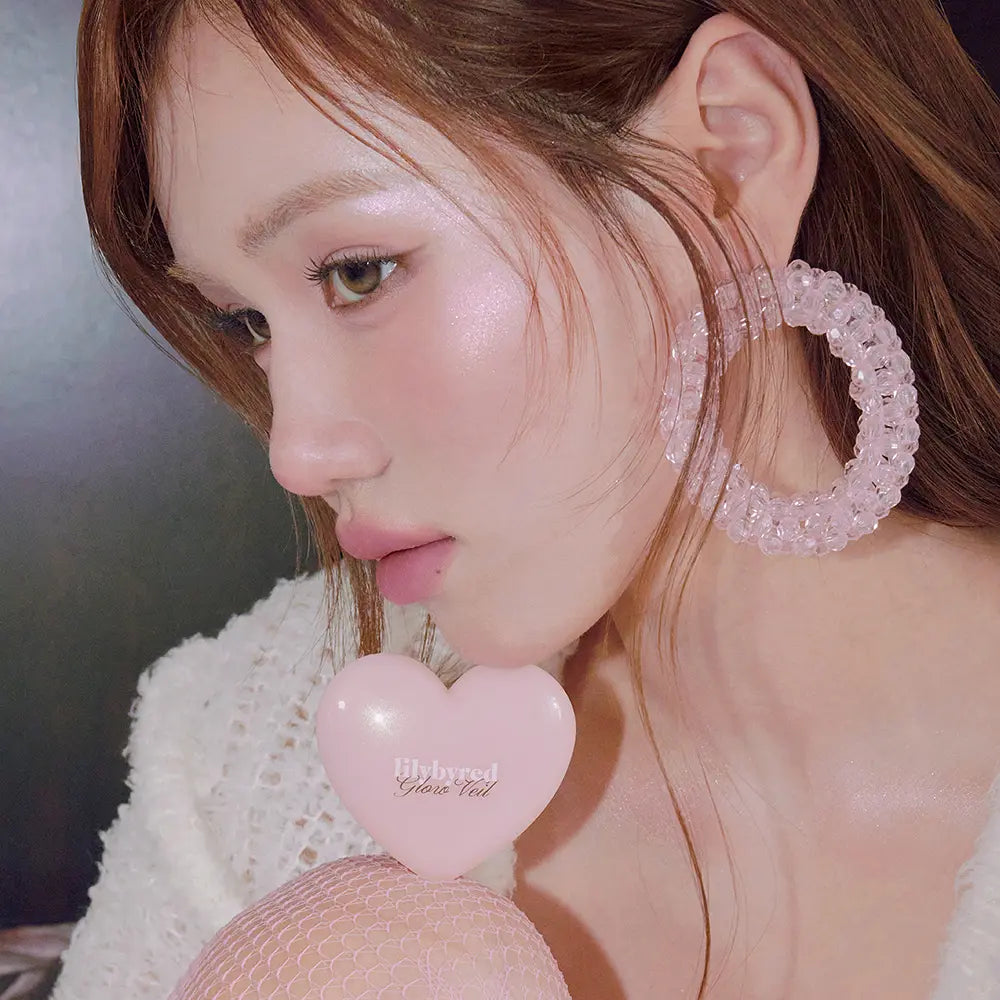 LILYBYRED Love Beam Glow Veil sur visage lumineux, gros plan maquillage avec cœur et accessoires, marque LILYBYRED, ambiance douce