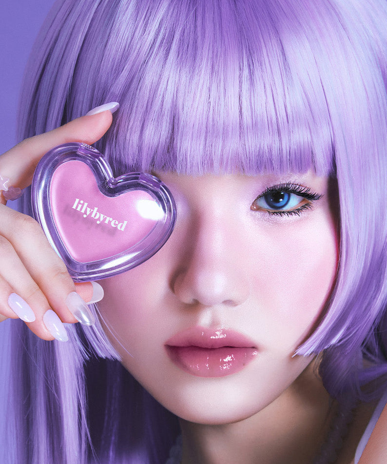 LILYBYRED Love Beam Sherbet Cheek, la marque, sur une main tenant un pot en forme de cœur, maquillage violet
