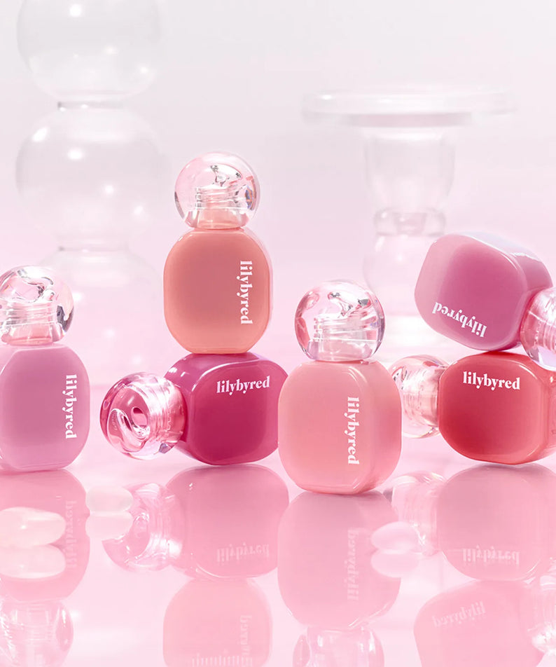 Collection de teintes LILYBYRED Balming Dewy Tint, avec une finition brillante et des couleurs vibrantes sur un fond rose.