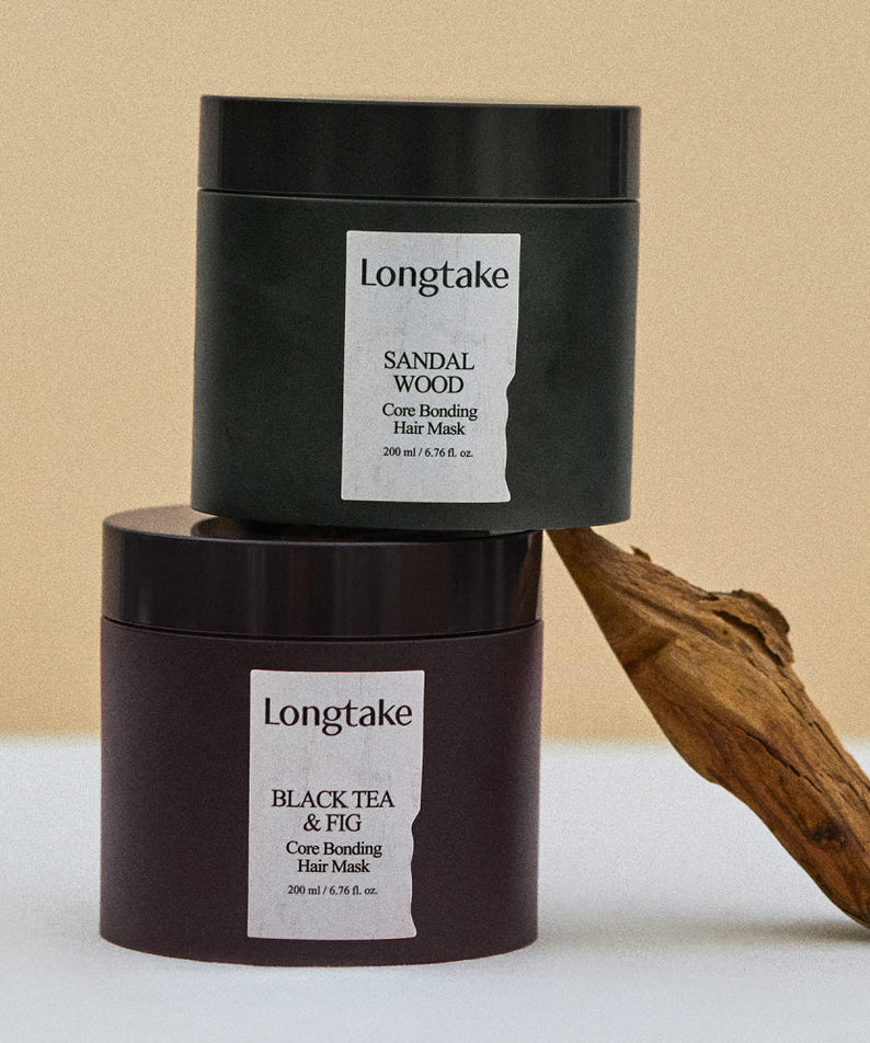 LONGTAKE Core Bonding Perfume Hair Mask Hair Pack 200ml Longtake, pot noir sur fond beige avec accessoires bois et étiquette