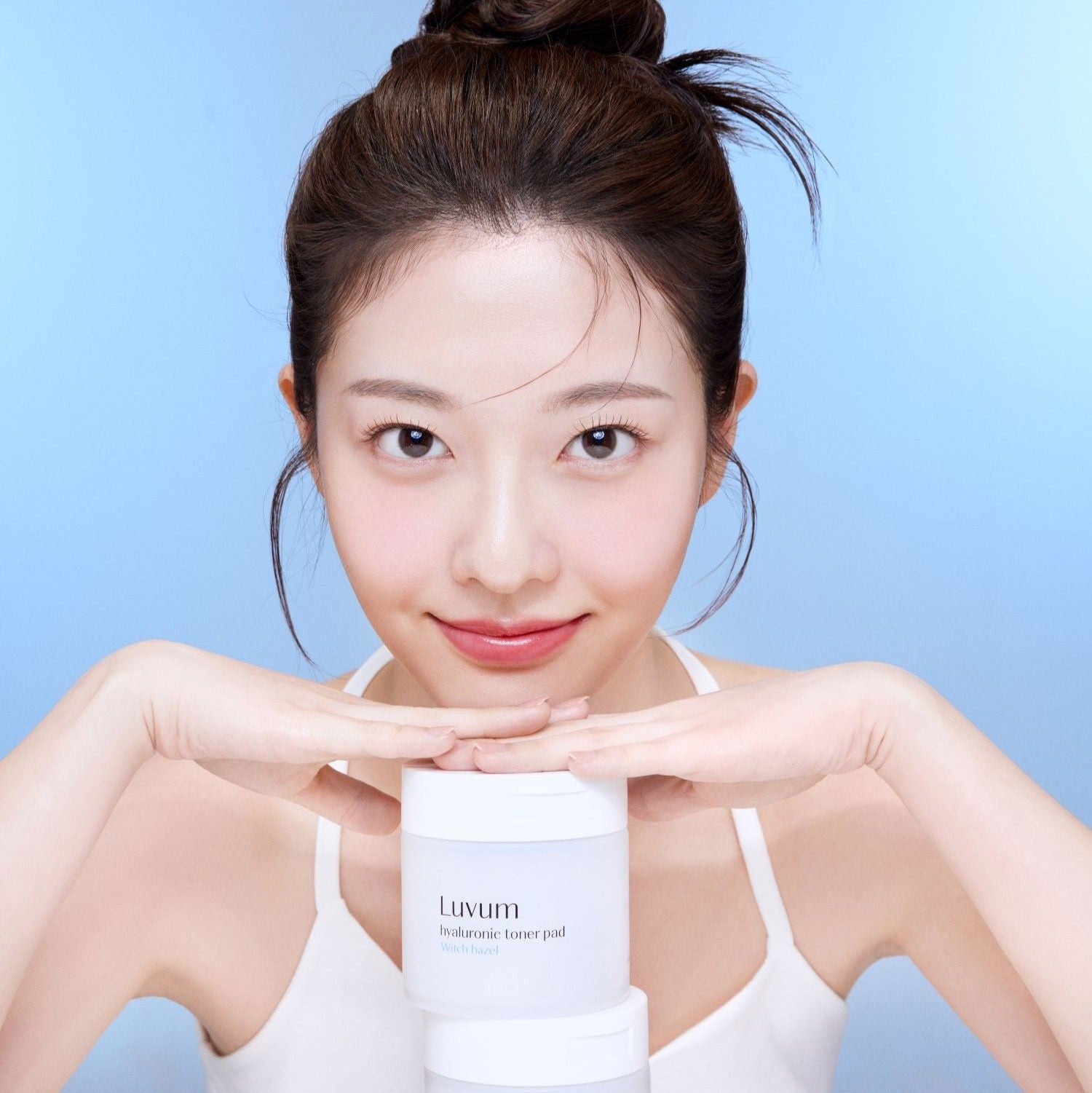 Décris l'image en français en mentionnant LUVUM 1 Hyaluronic Acid Toner Pads 60 Sheets : femme tenant des pads tonifiants Luvum.