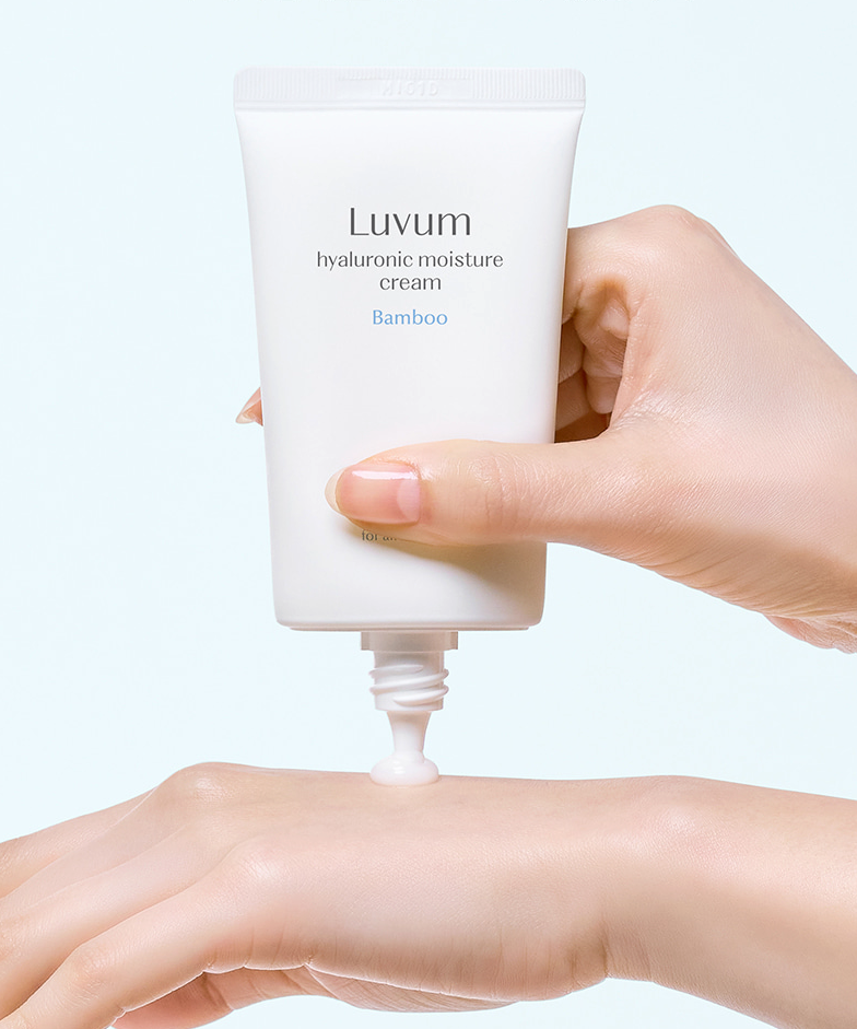LUVUM Bamboo Hyaluronic Acid Moisture Cream 70ml, tube crème sur peau, main appliquant, fond clair lumineux.