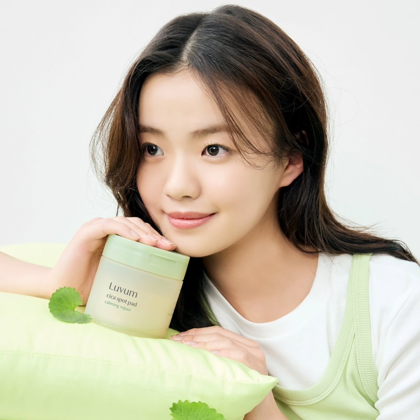 LUVUM Calming Repair Cica Spot 60 Pads : femme tient un pot, ambiance naturelle, marque Luvum, feuilles vertes