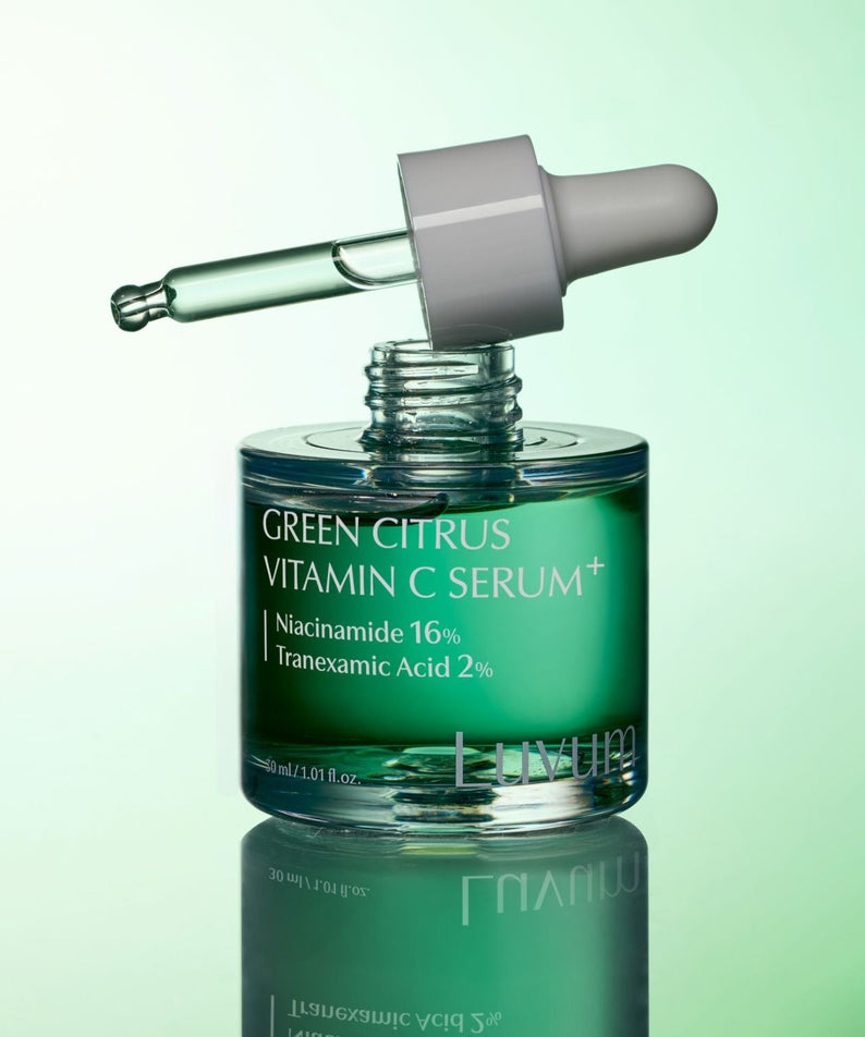 Décris l'image en français : LUVUM Green Citrus Vitamin C Serum Plus 30ml, flacon vert sur fond vert, goutte de sérum