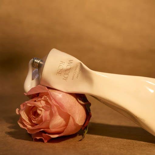 LUVUM Woody Rose Perfume Hand Cream 50ml en flacon crème, marque LUVUM, rose décorative sur fond beige