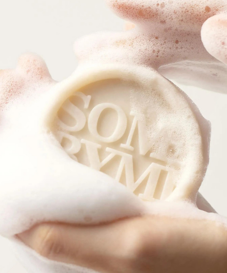 SOME BY MI Lacto Soy pH Morning Cleansing Bar, savon moussant en mains, marque coréenne, contexte salle de bain