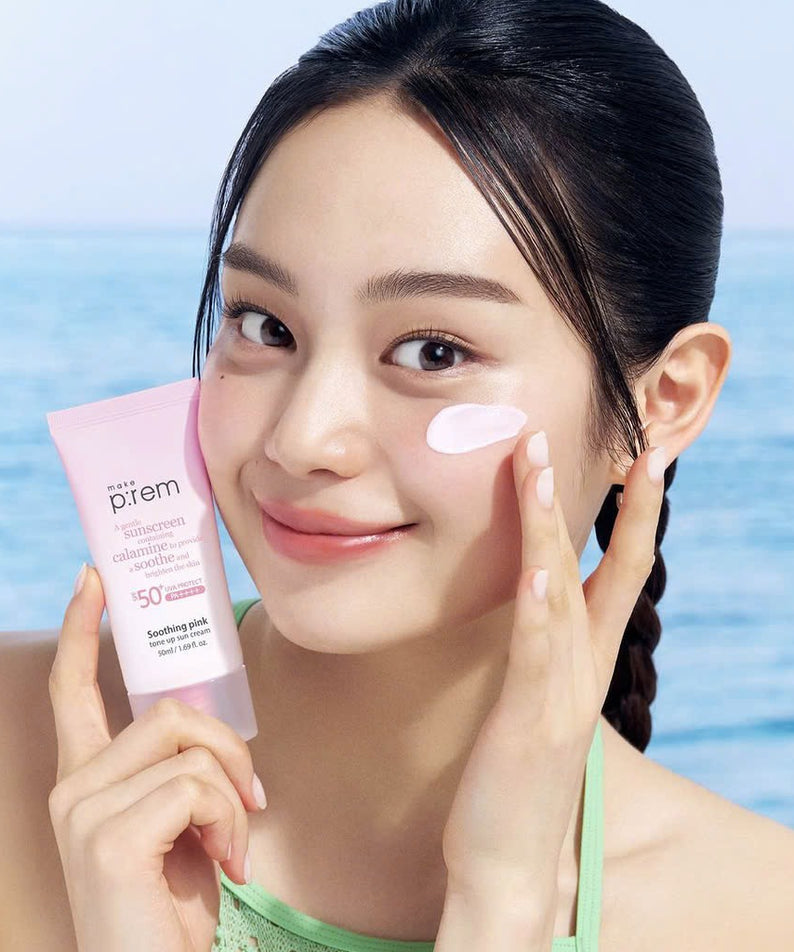 MAKE P:REM  Soothing Pink Tone-Up Sunscreen SPF 50+ PA++++ 50ml, femme à la plage, crème solaire rose sur le visage.